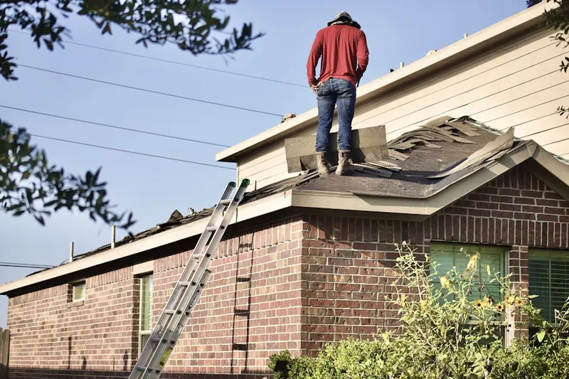 Professional roofer working on a residential roof in Praesel